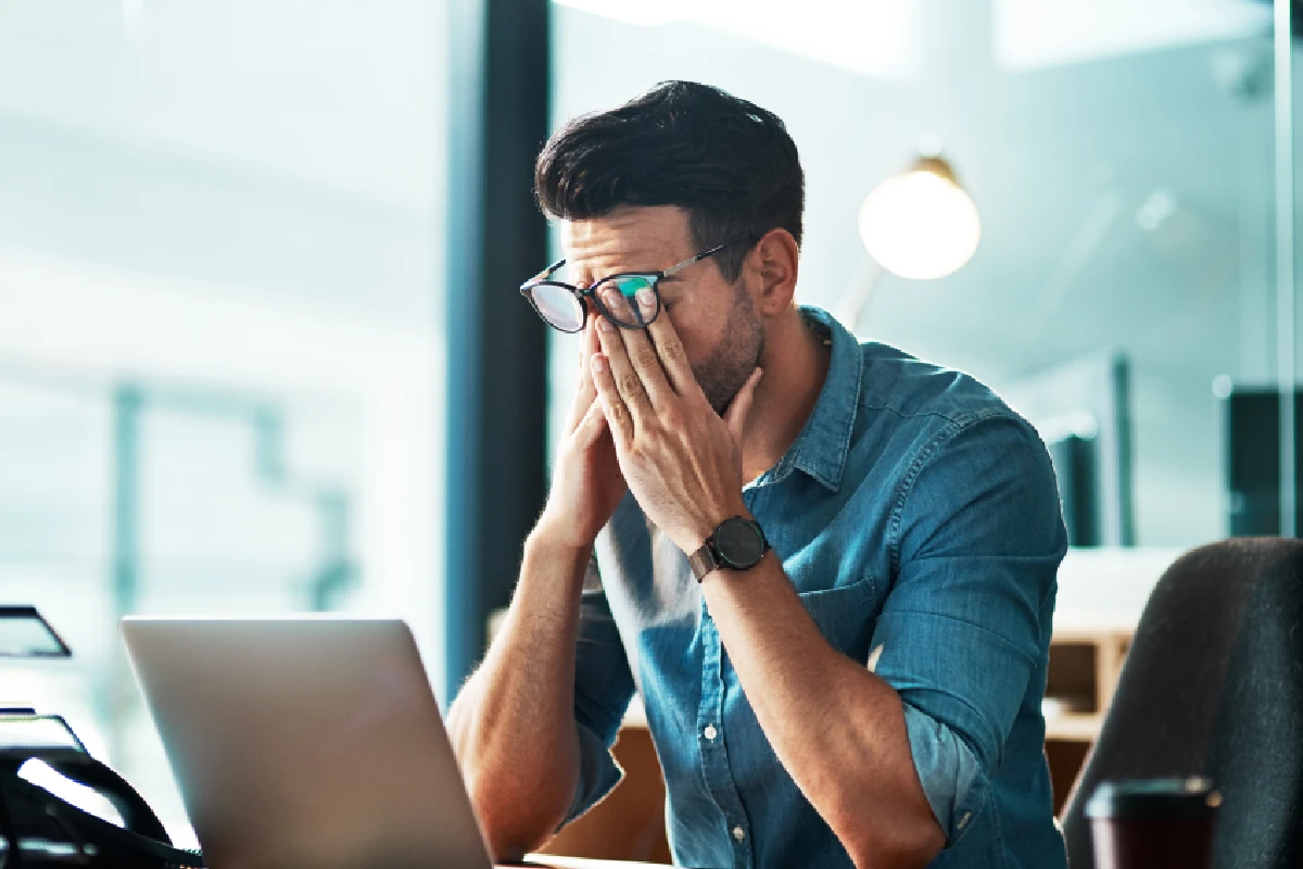Man experiencing persistent fatigue and low energy at work due to hormonal imbalance.